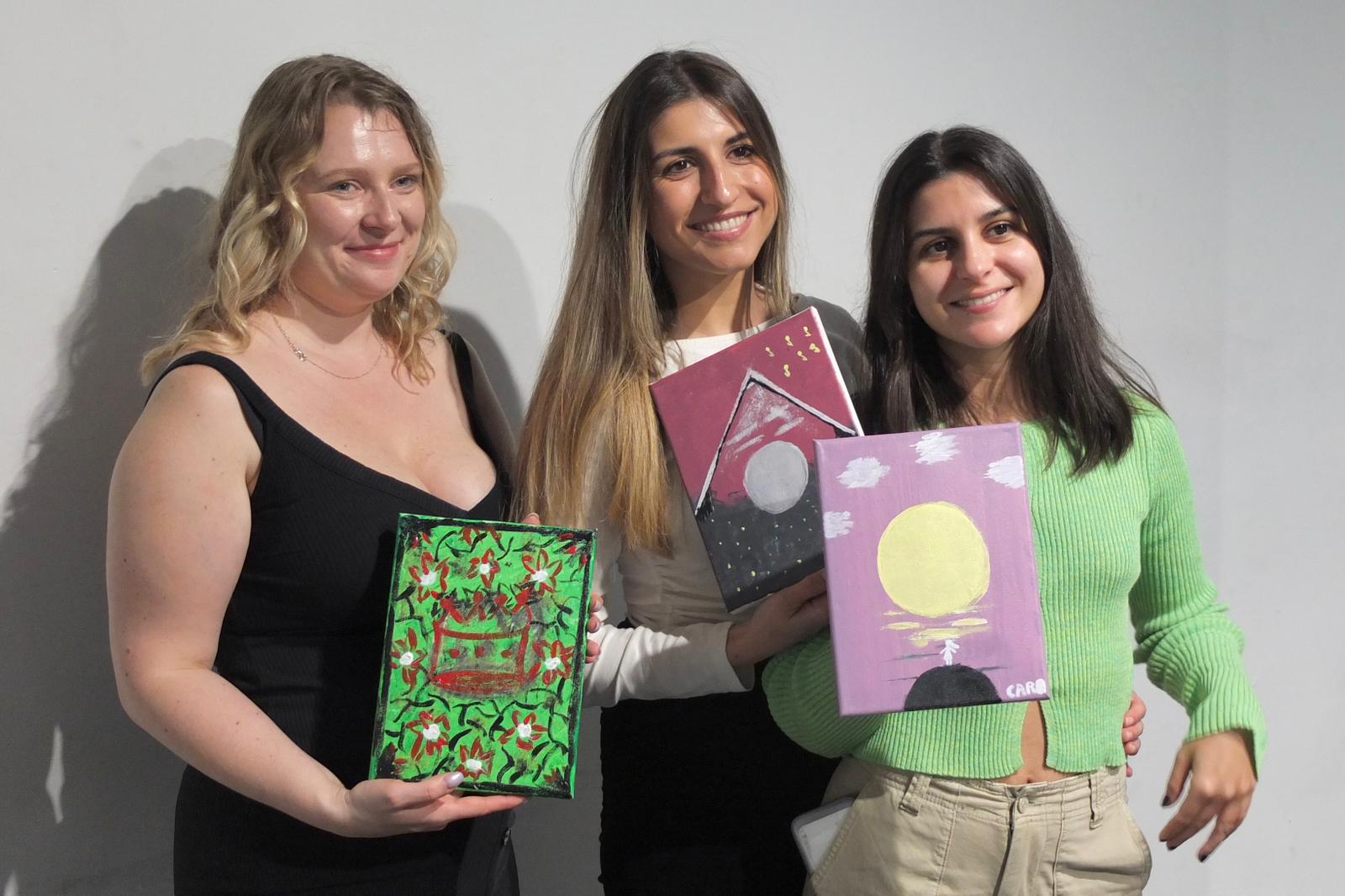 Tres amigas con sus obras