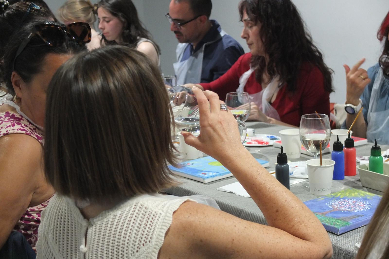 Mesa con copas, pinturas y lienzos